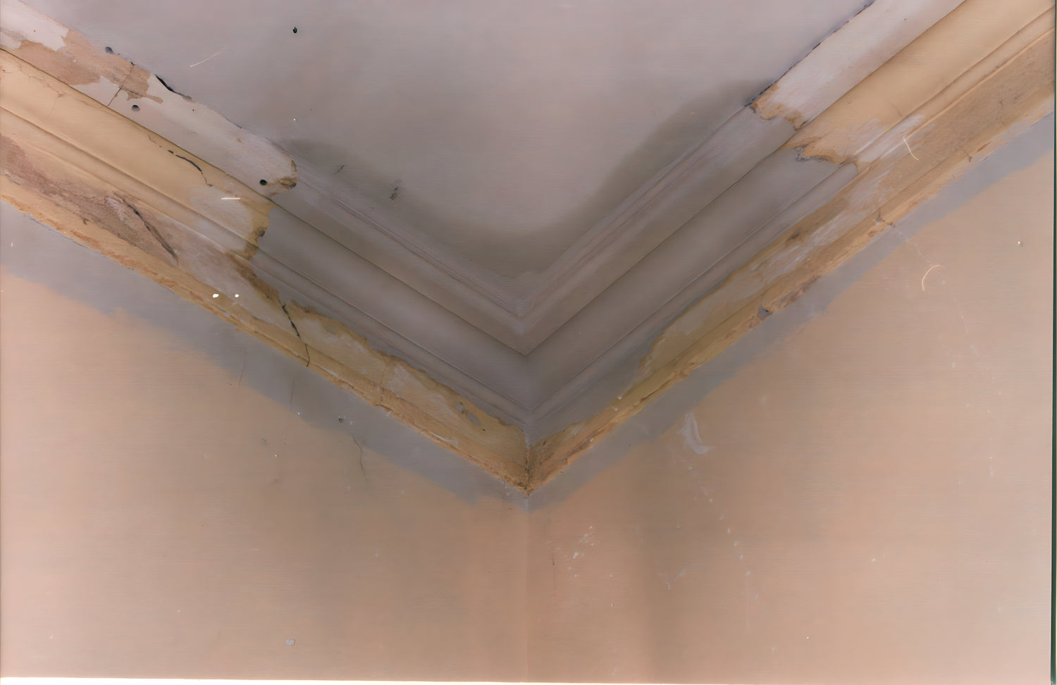 Corner of a ceiling with visible damage and repair work.