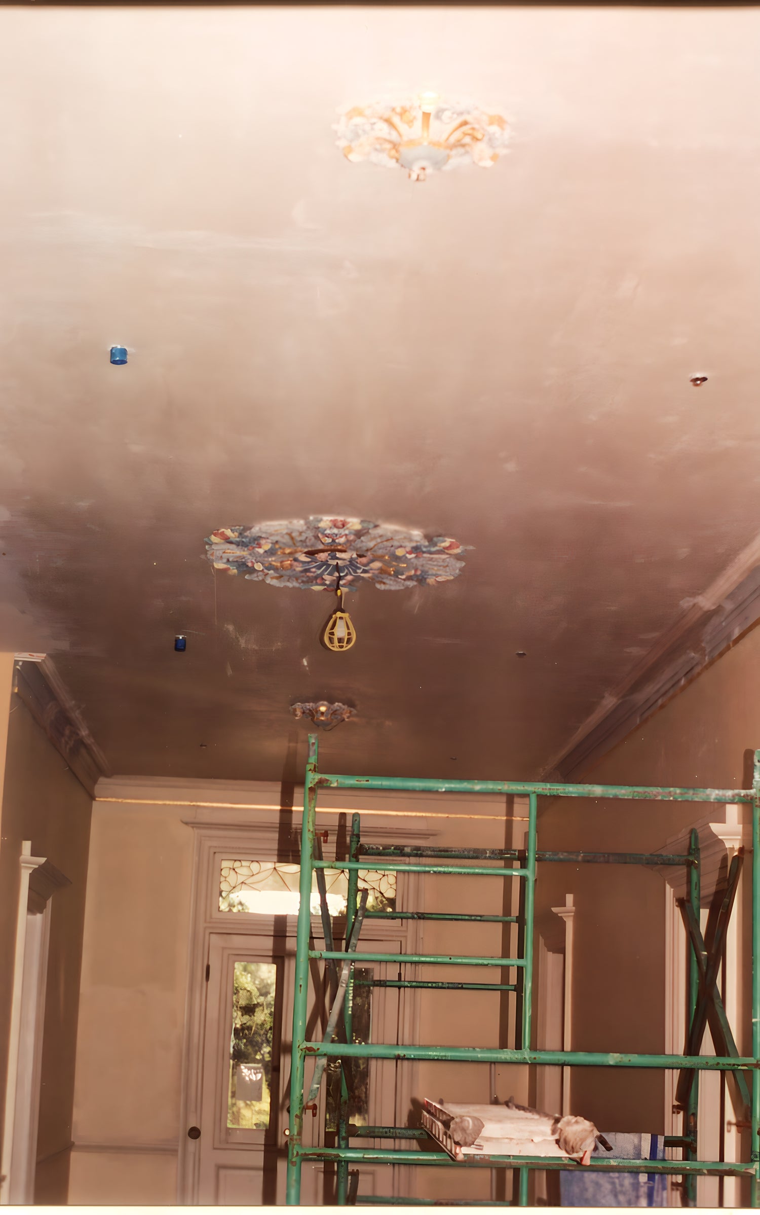 Ceiling with decorative element and scaffolding in a room