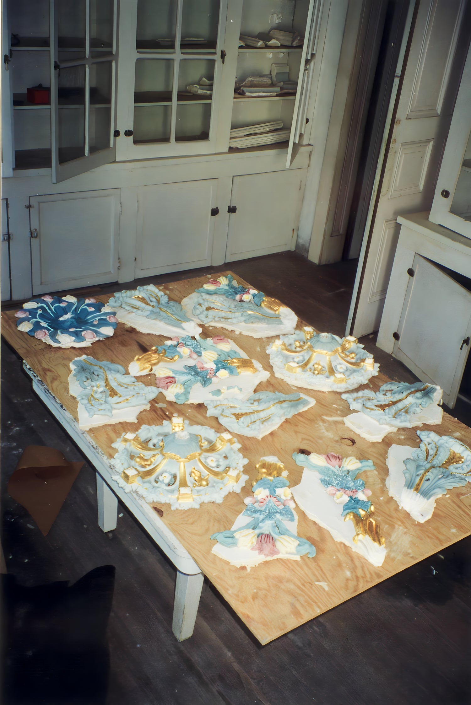 Puzzle pieces on a table in a room with cabinets and a door.