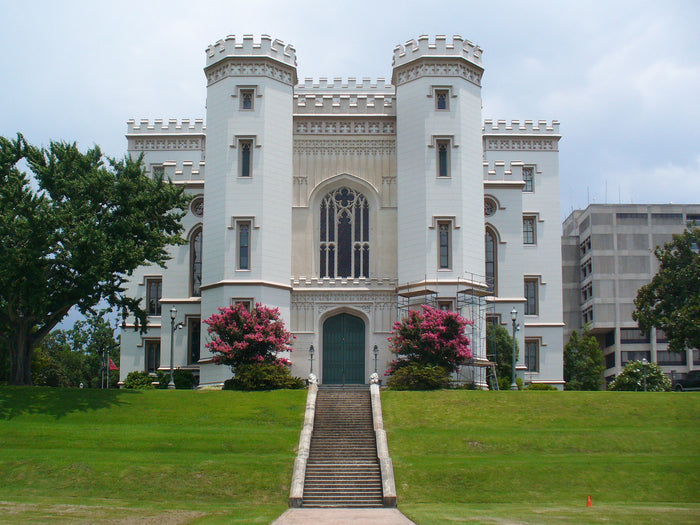 White castle-like building with decorative architecture on a grassy lawn