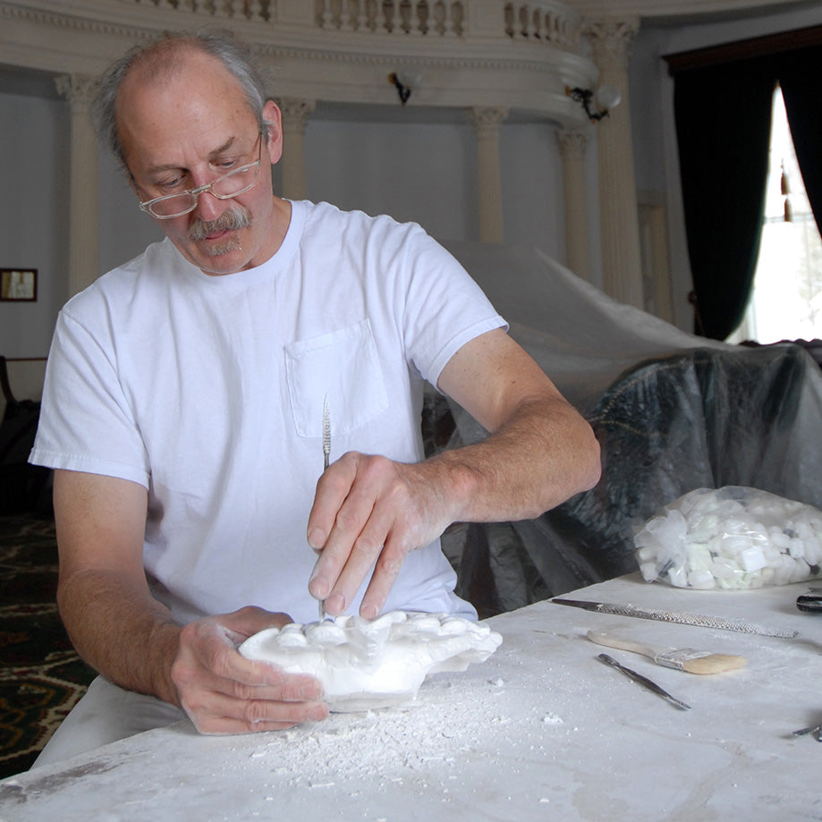 Man working with white material on a table in an indoor setting