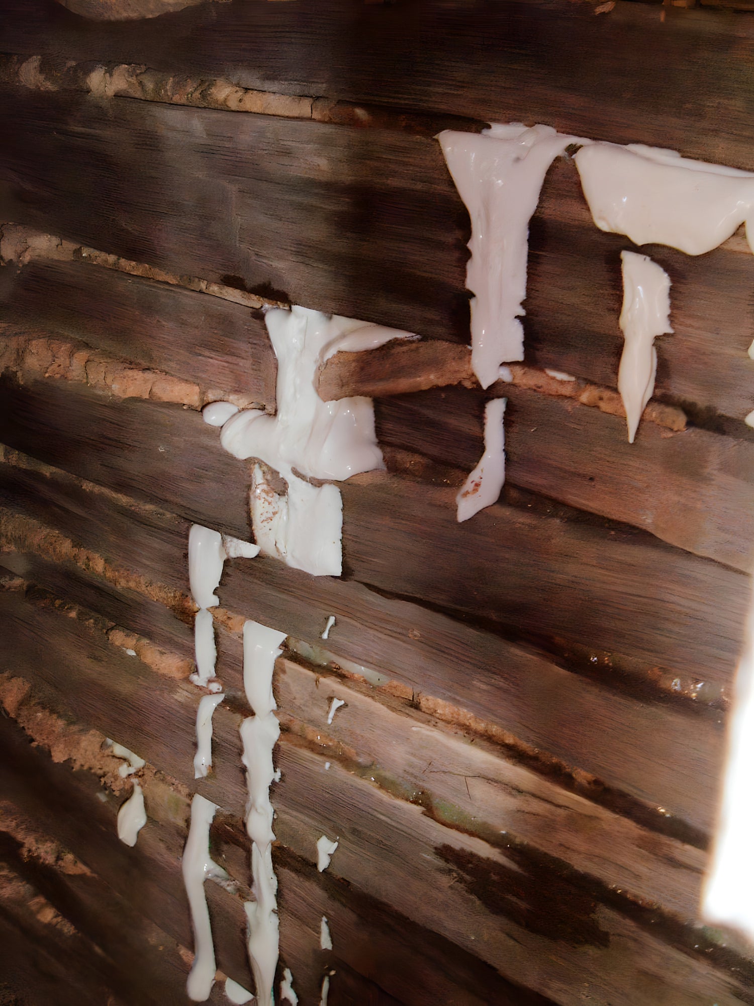 Wooden wall with white patches of paint