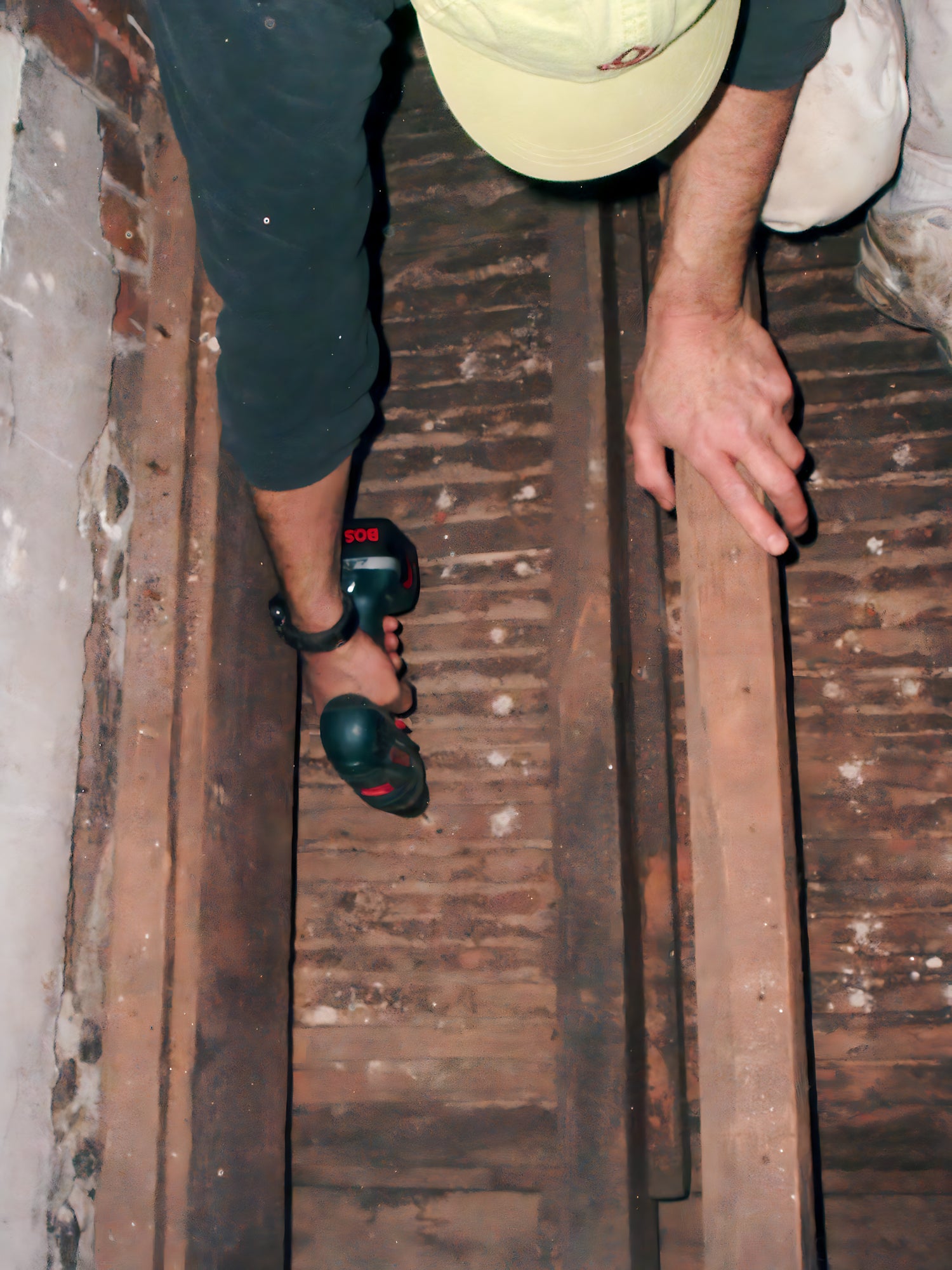 Person walking on wooden planks over a gap, wearing sandals.