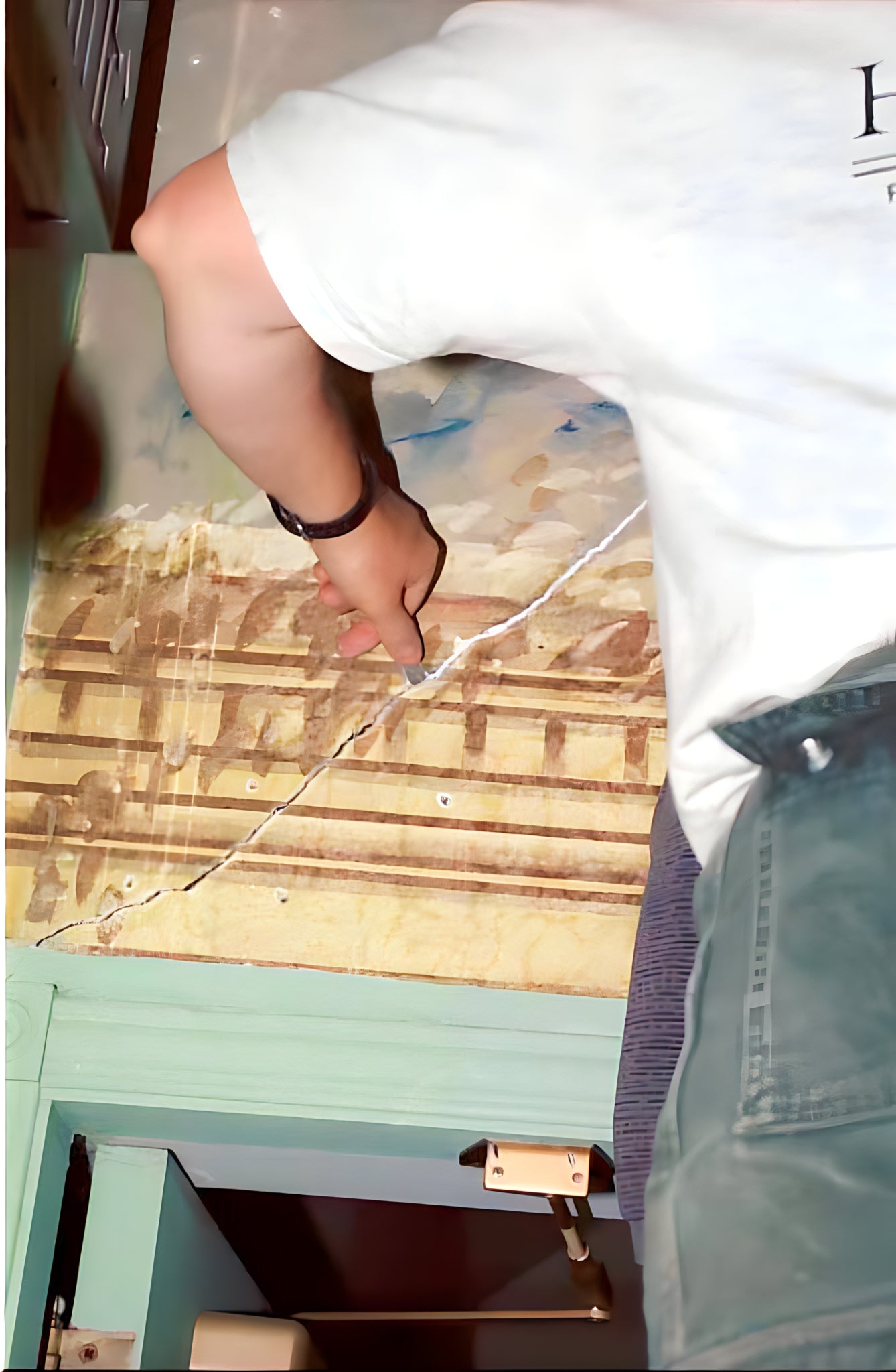 Person working on a wooden floor with tools
