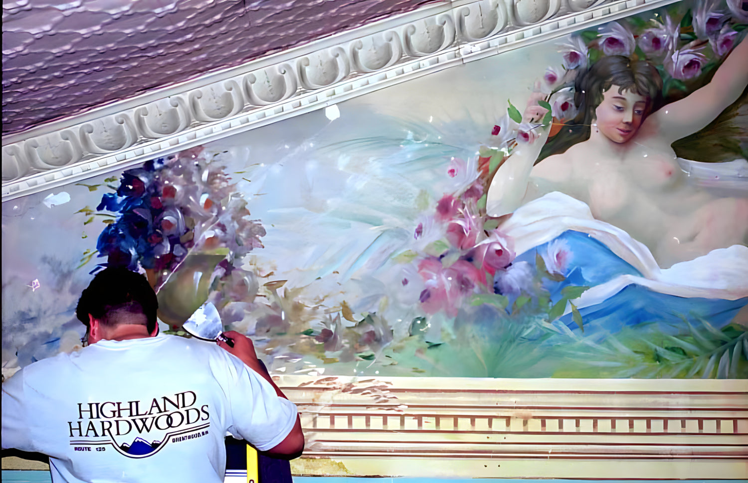 Person measuring a decorative wall mural with 'Highland Hardwoods' logo.