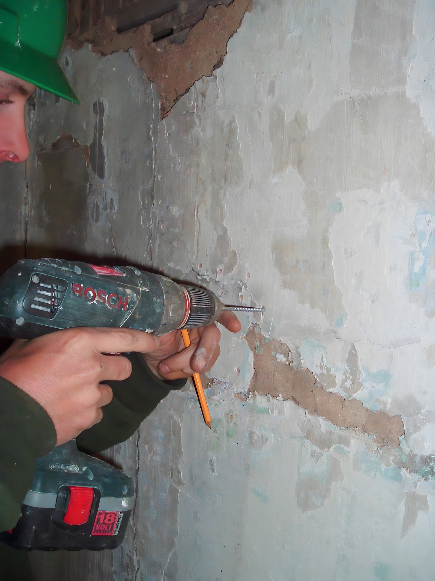 Person using a Bosch drill on a wall
