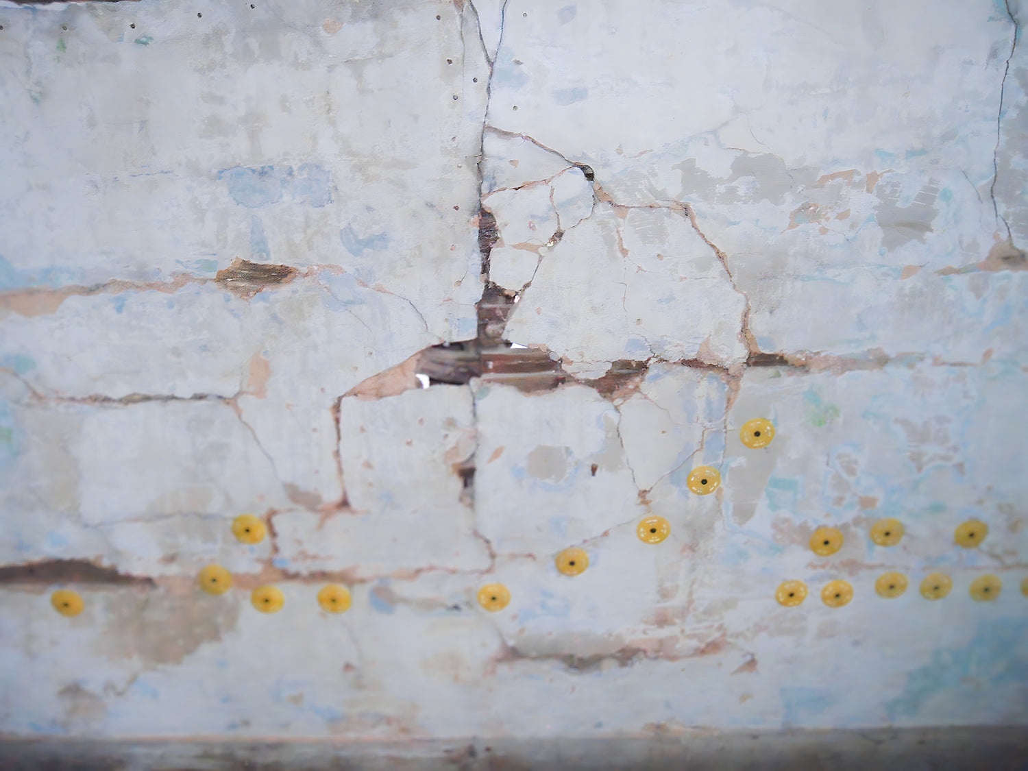 Marble surface with cracks and yellow circular marks