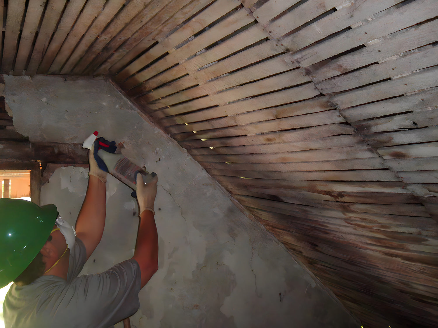 Person working on a ceiling with wooden slats and tools.